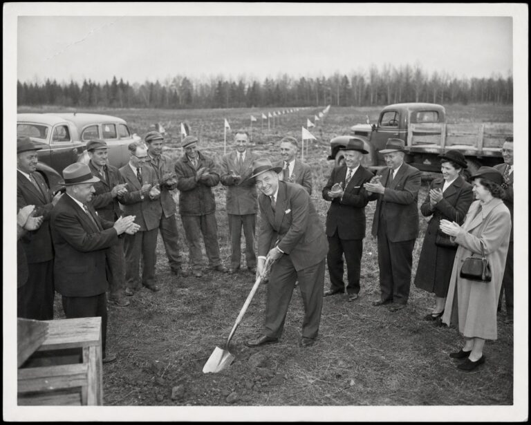 Ceremonial first shovel at the 1949 groundbreaking, crowd applauding in a field