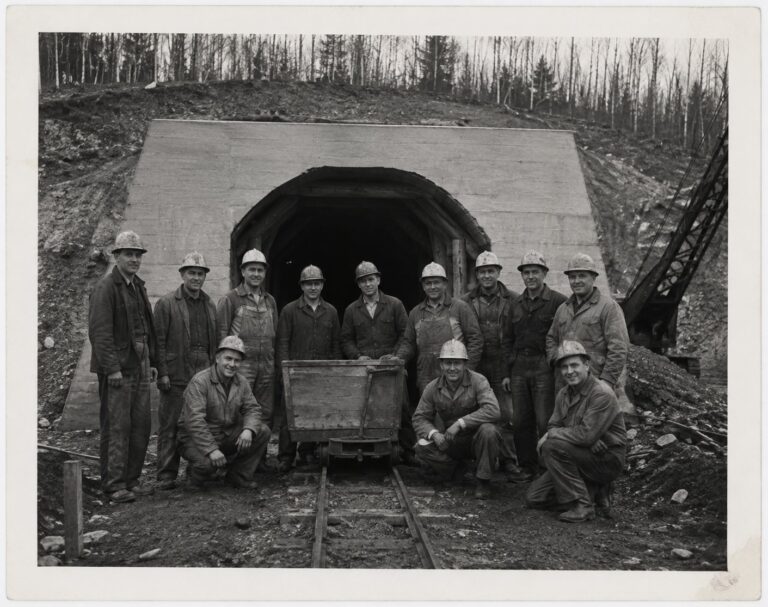Work crew in hard hats posed at the concrete tunnel portal, circa 1955